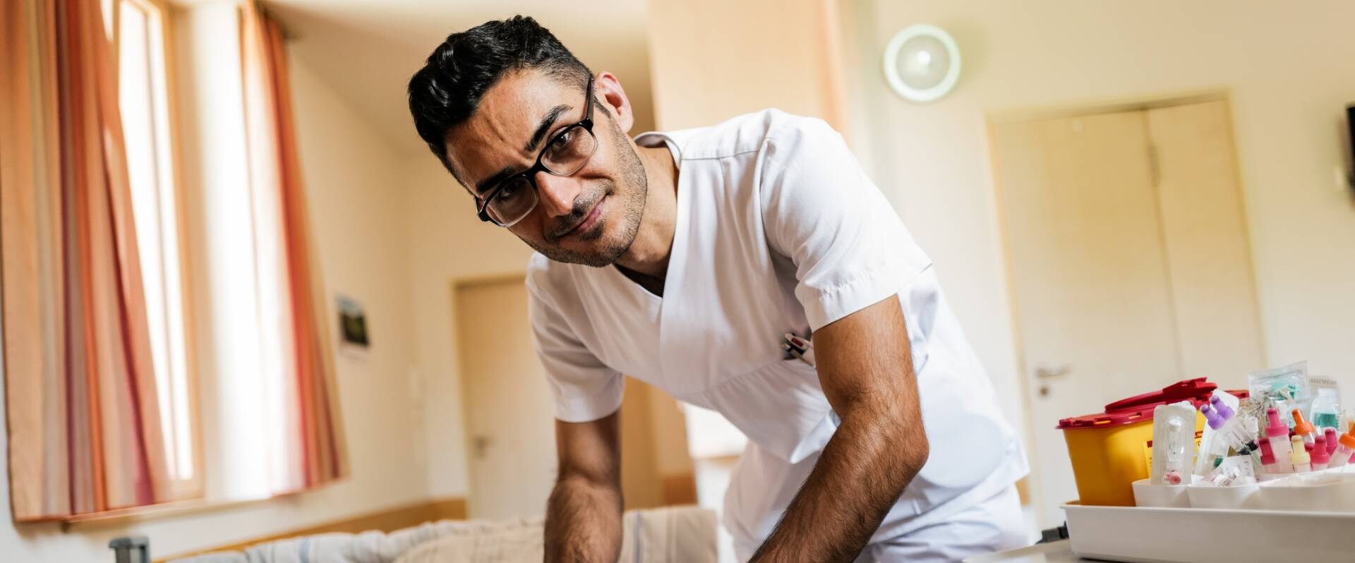 Medizinisches Personal mit Brille lächelt freundlich