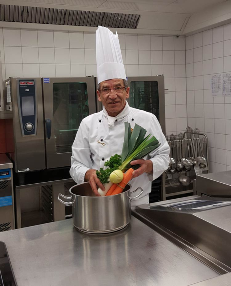 Abbildung des Küchenleiters Wolfgang Lahn in einer Küche. 